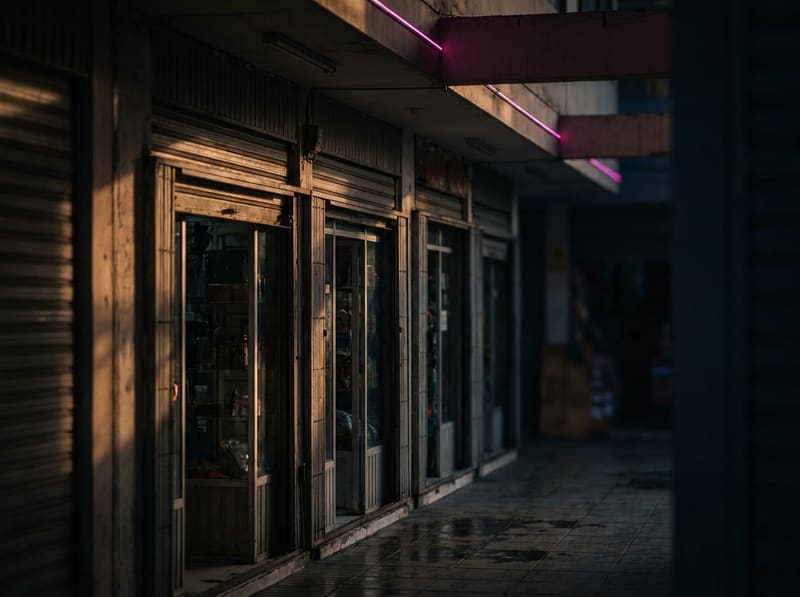 Pasillo de una galería comercial con tiendas pequeñas al atardecer